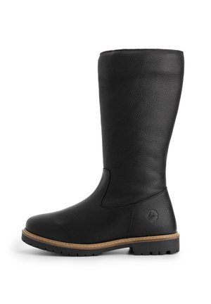 Botte en cuir noir haute avec une semelle plate, des coutures de welt marron et un petit logo embossé près du talon sur un fond blanc.