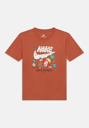 Tričko s krátkym rukávom v hrdzavej farbe vyrobené z bavlny, s grafickým dizajnom obsahujúcim nápis „Nike“, kvety a prvky športového náradia.