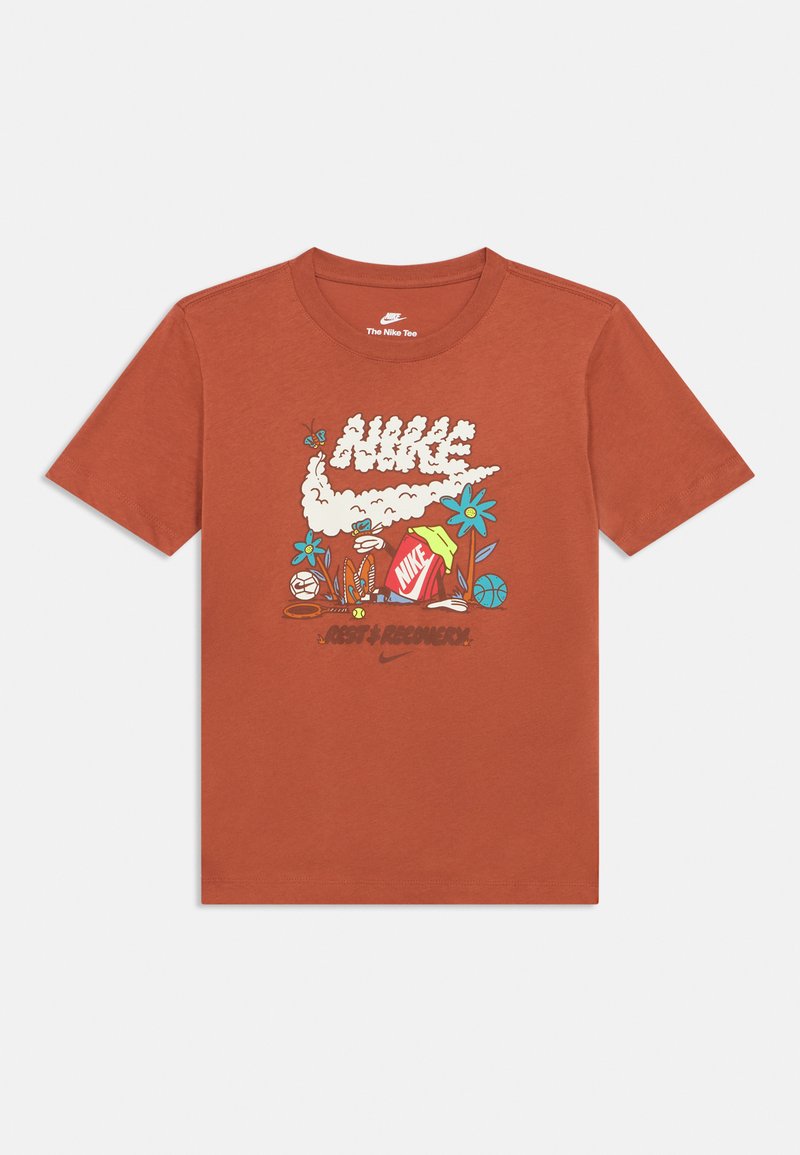 T-shirt à manches courtes de couleur rouille en coton, avec un motif graphique comprenant le texte "Nike", des fleurs et des éléments d'équipement sportif.