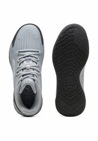 Baskets de sport gris clair avec un dessus texturé, un laçage et une semelle en caoutchouc noire dotée d'un motif de traction en zigzag.