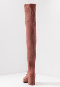 Różowe, zamszowe botki z wysoka cholewką i kwadratowym obcasem. Szwów biegnąca wzdłuż tyłu. Gładka tekstura i dopasowany krój.