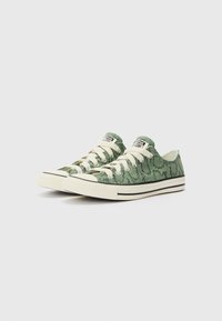 Adidași verzi cu un model imprimat cu șarpe, șireturi albe și detalii cu dungi negre pe talpă. Design de tip low-top cu vârful din cauciuc.