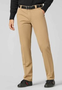 Beige chino's van katoenmix, met een rechtvallend ontwerp, voorzakken en een zwarte leren riem. Versterkt met zwarte sneakers.