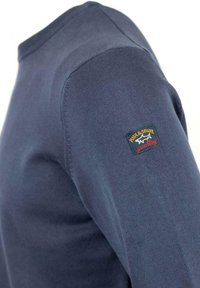 Maglione a maglia blu navy con collo a giro, caratterizzato da un tessuto testurizzato e una patch con logo sulla spalla sinistra.
