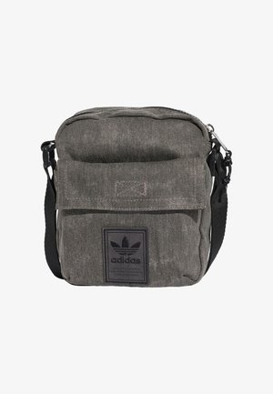 Grå Adidas crossbody taske med frontlågslomme og sort justerbar rem, med Adidas logo på frontlommen.