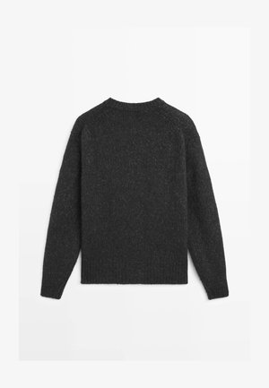Mørkegrå strikket sweater med lange ærmer, rund halsudskæring og ribbet kant. Teksten ser blød og let chunky ud.