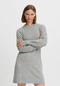Vestito grigio a maglione con corpo a coste, maniche a palloncino con lavorazione a treccia e scollatura tonda. Texture liscia e lunghezza fino a metà coscia.