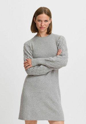 Graues Strickkleid mit geripptem Körper, kabelgestrickten Puffärmeln und rundem Ausschnitt. Glatte Textur und Länge bis zur Mitte des Oberschenkels.