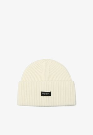 Hvid strikket hue med ribbet tekstur, foldet manchet og et sort mærke syet på forsiden. Velegnet til brug i koldt vejr.