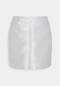 Mini-jupe métallisée argentée avec une texture lisse, dotée d'une fermeture éclair au dos et de coutures avant distinctes. Coupe ajustée sans motifs.