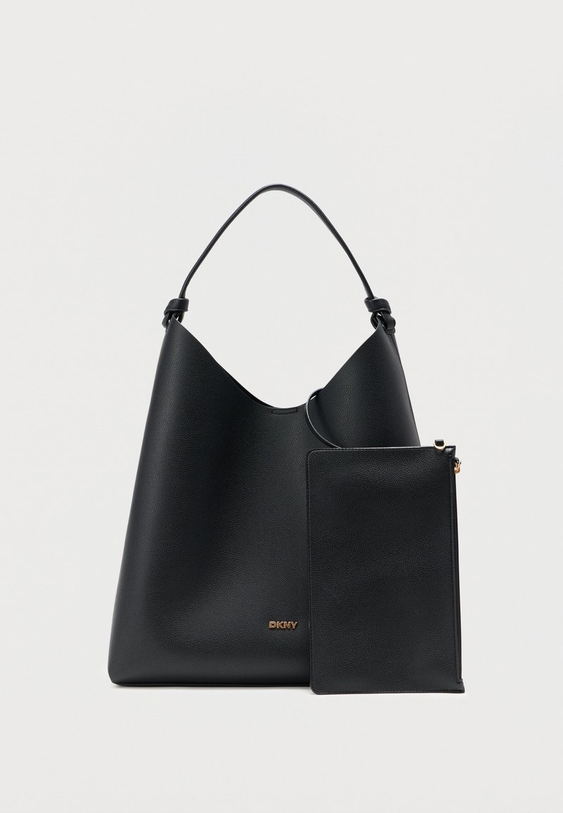 Sac à bandoulière en cuir noir avec petite pochette assortie, logo doré DKNY sur le devant, sur fond uni.