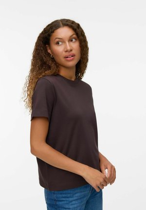 Brun T-shirt med korte ærmer og rund hals i glat stof; kombineret med blå jeans med en afslappet pasform.
