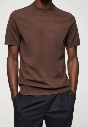 Bruin gebreide korte mouw trui met een ronde hals. Geribde zoom en manchetten, zachte textuur, aangesloten ontwerp, gecombineerd met donkere broek.