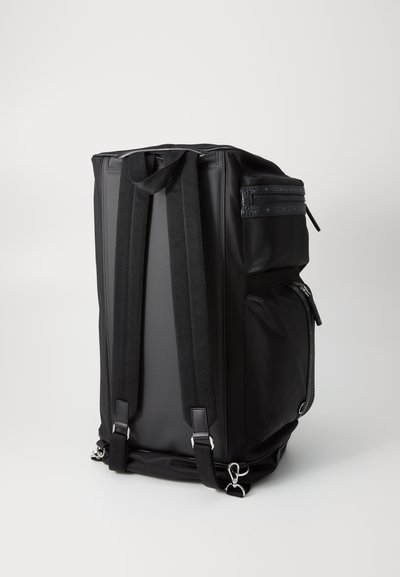 Black backpack featuring a textured upper, two shoulder straps, a zip pocket, and polished hardware accents. Smooth, durable material.
