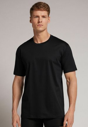 Schwarzes Kurzarm-T-Shirt aus glattem Stoff, mit Rundhalsausschnitt und lockerer Passform. Einfaches Design ohne Muster oder Akzente.