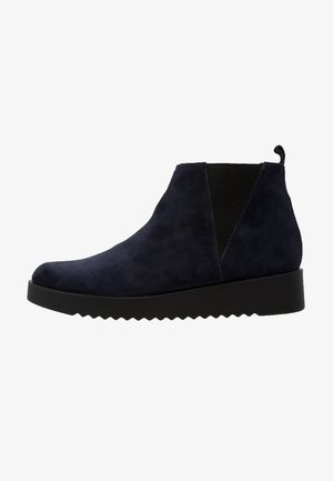 Stivaletto Chelsea in suede blu scuro con pannello elastico nero ai lati, linguetta sul retro e suola nera spessa e rigata.