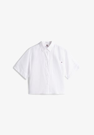 Vit kortärmad skjorta med knappslå, spetsig krage och framficka; tillverkad av lätt material; har ett litet varumärkesemblem.