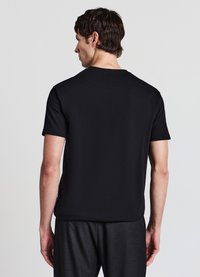 T-shirt nera a maniche corte con scollo rotondo, realizzata in un tessuto liscio. Presenta un design semplice, privo di motivi o loghi.