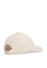 Beige cotton baseball cap with a curved visor, adjustable metal buckle at the back, and stitched ventilation holes on the crown.