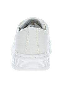 Sneakers bianchi in tela con tacco arrotondato, suola testurizzata e dettagli cuciti. Presentano un colletto imbottito e una morbida fodera interna.