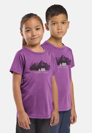 Deux enfants se tiennent côte à côte, portant des t-shirts violets assortis "Nature’s Nomads" avec des motifs de montagnes et de feu de camp.