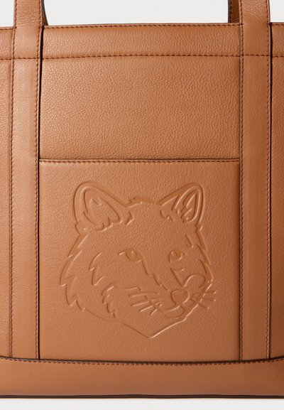 Τσάντα ώμου από ταμπά δέρμα με ανάγλυφο σχέδιο κεφαλής αλεπούς, χαρακτηριζόμενη από ομαλή υφή, ορθογώνιο σχήμα και ανθεκτικές επίπεδες λαβές.