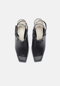 Zwarte leren slingback schoenen met vierkante neuzen, verstelbare enkelbandjes en zilveren hardware accenten. Gladde textuur en minimalistisch ontwerp.