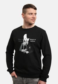 Felpa nera con stampa grafica di due personaggi, uno in scala di grigi e l'altro a colori, con il testo "Una volta Addams / Sempre Addams."
