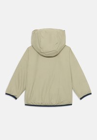 Light beige jacket with a hood, elastic cuffs, and navy blue accents at the hem. Smooth texture, simple design, and a relaxed fit.
