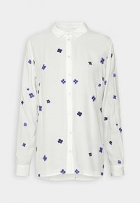 Chemise blanche à manches longues, boutonnée, avec petits motifs floraux violets et bleu foncé dispersés et col classique.