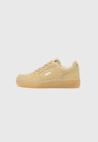 Beige sneakers with smooth leather upper, rounded toe, and rubber sole. Features padded tongue, lace-up closure, and subtle branding on the side.