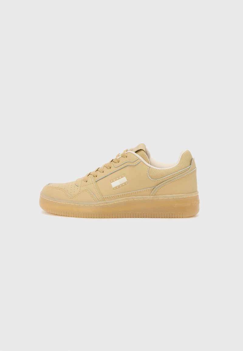Beige sneakers with smooth leather upper, rounded toe, and rubber sole. Features padded tongue, lace-up closure, and subtle branding on the side.