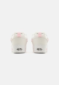 Witte sneakers met roze accenten, gewatteerde kraag, ronde neus en een gestructureerde witte rubberen zool. Voorzien van Vans-merk op de hiel.