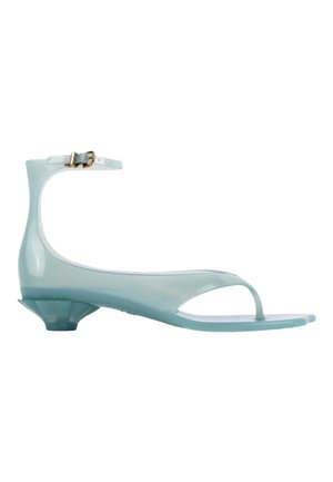 Sandale translucide bleu clair à petit talon, bride à la cheville, bout ouvert et design en tongs sur fond blanc.
