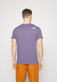 Lila kortärmad t-shirt med rund halsringning och logotypdetalj på övre ryggen. Mjuk tyg med en slät textur.