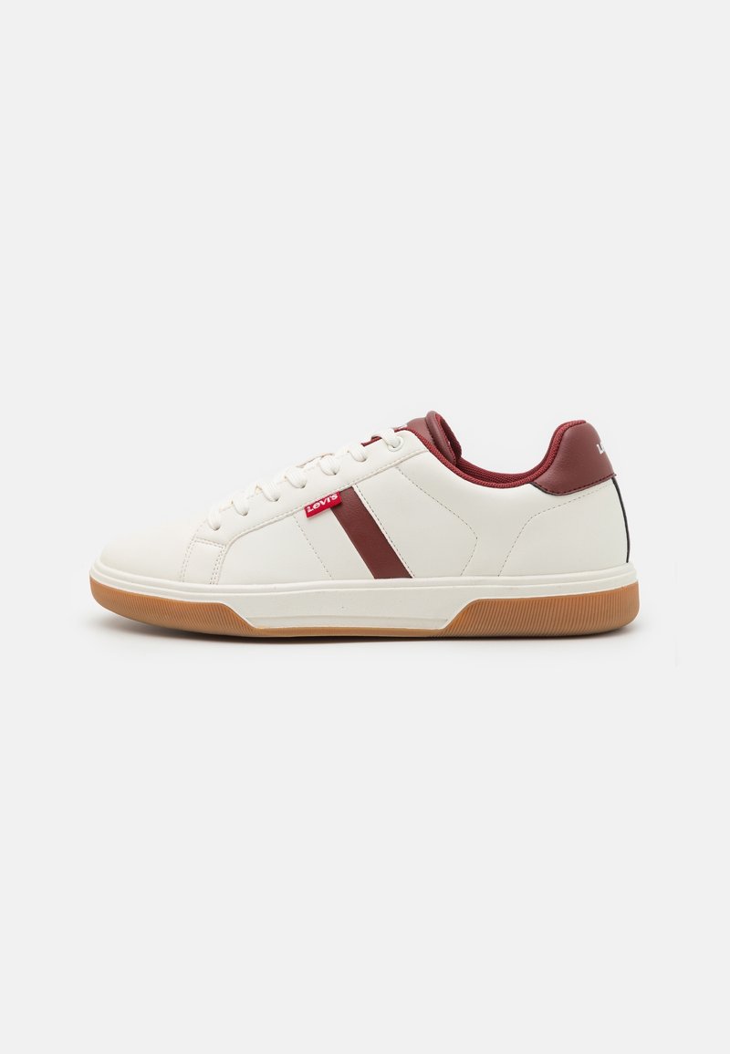 White sneaker with burgundy accents, low-top design, textured rubber sole, and logo detail near the laces; smooth synthetic upper.