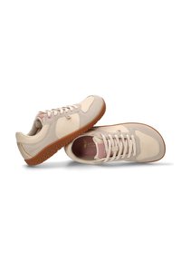 Zapatillas casuales en color beige y rosa claro con suelas de goma, cordones y interiores acolchados, posicionadas con un zapato tumbado de lado.
