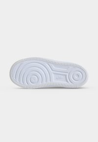 Σόλα λευκού παπουτσιού Nike με κυκλικά και γραμμικά σχέδια πέλματος και το λογότυπο Nike ανάγλυφο κοντά στο κέντρο.