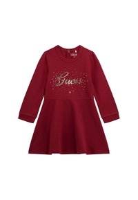 Abito lungo a maniche per bambina in bordeaux con gonna svasata, scollatura rotonda, chiusura con zip sul retro e logo "Guess" abbellito con strass sul petto.