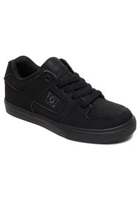 Black athletic sneakers with a suede and mesh upper, circular perforations on the toe, and a rubber sole. Features a logo on the side.