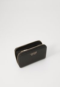 Portafoglio nero con texture, dotato di hardware in oro e logo. Presenta una chiusura con zip e un design compatto per un facile accesso ai contenuti.