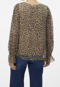 Blusa trasparente con stampa leopardata, maniche lunghe e polsini arricciati, con scollatura rotonda e vestibilità ampia, in tonalità di beige e nero.