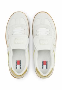 Sneaker bianche con tomaia in suede e rete, con un accento giallo. Suola in gomma, lacci rotondi e patch con logo sulla linguetta.