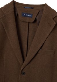 Brauner Strickblazer mit Reverskragen, ein schwarzer Knopfverschluss und einer Brusttasche. Etikett mit der Aufschrift "PIOMBO". Glatte Textur.