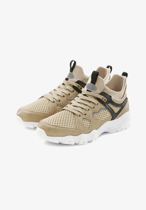 Beige athletic shoes with a mesh upper, textured synthetic accents, black trim, and a white sole. Features secure lacing and pull tabs.