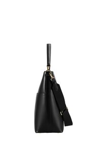 Schwarze Lederhandtasche mit breitem, verstellbarem Schulterriemen und kurzem Griff, von der Seite vor weißem Hintergrund gezeigt.