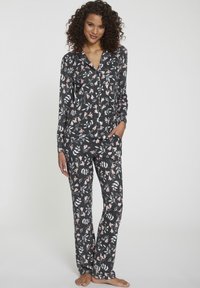 Floral pyjamastel in het zwart met roze en witte patronen, met lange mouwen, een overhemd met knoopjes en bijpassende broeken. Zachte stof.