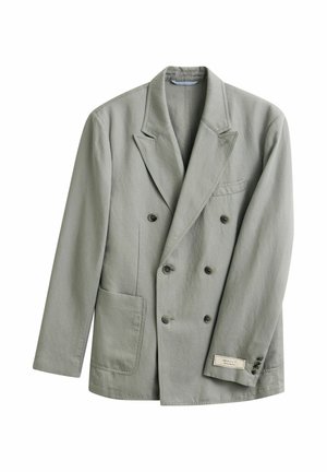 Blazer gris clair croisé avec revers à encoches, devant à quatre boutons, deux poches et une petite étiquette de marque sur le poignet de la manche gauche.