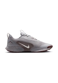 Gray athletic shoe with a textured upper, contrasting brown accents, breathable mesh design, and a flexible rubber sole.