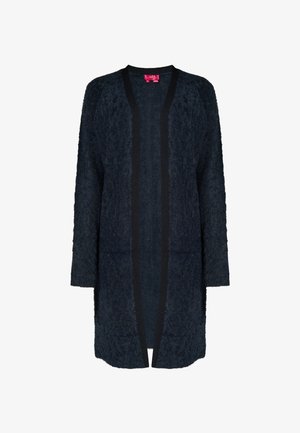 Tengerészeti textúrájú kardigán hosszú ujjakkal, nyitott elülső kialakítással és kontrasztos fekete szegéllyel a széleken. Puha, bolyhos anyag.